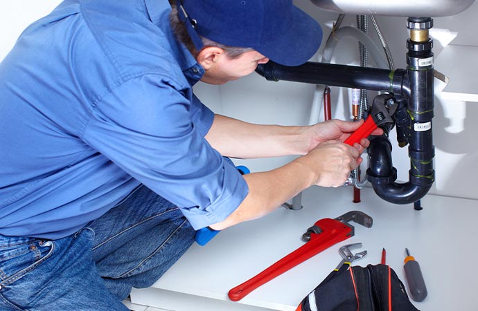 Plumber expertly repairing a leaky pipe.
