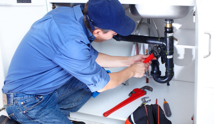 plumber repairing kitchen sink